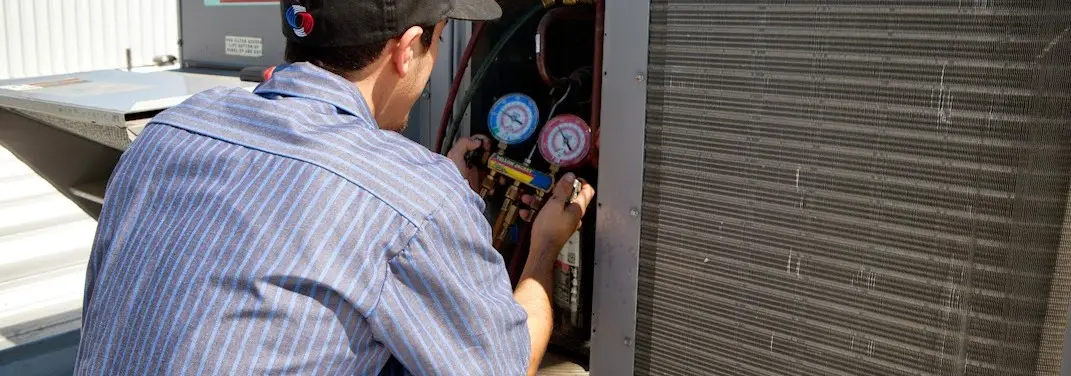 HVAC technician servicing a condenser unit in Layhill