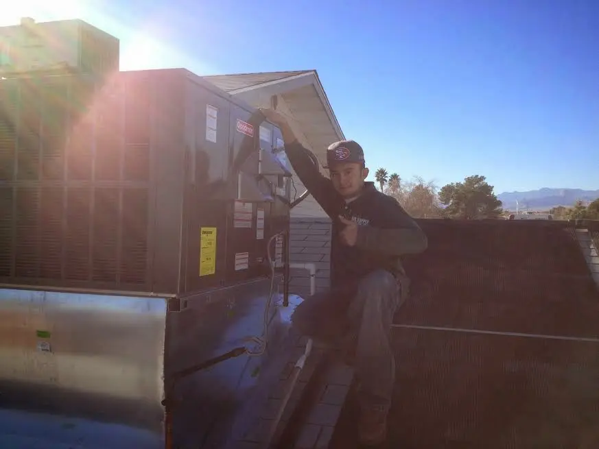HVAC technician performing Air Duct Repair on a rooftop unit in Layhill